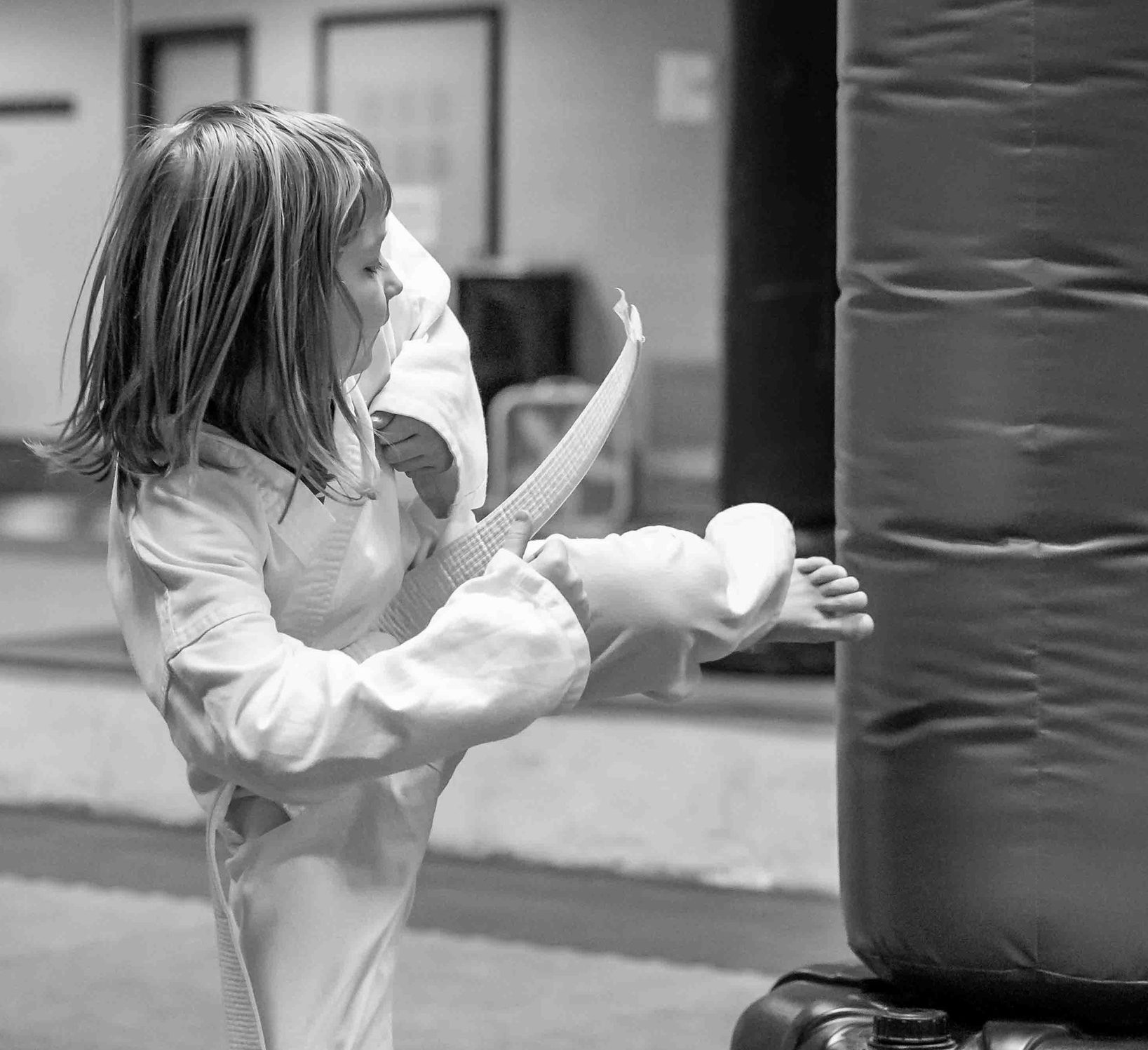 A young student practicing on a heavy bag